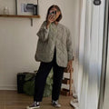 Women's lightweight quilted jacket with round neckline, quilted waves, and press buttons
