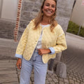 Women's quilted short jacket with diamond quilting, contrasting piping, and rounded hem